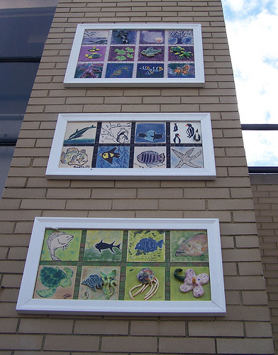 Three panels shine against the backdrop of the sky at the NY Aquarium