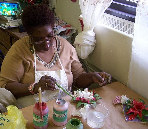 Artist sculpting a flower tile