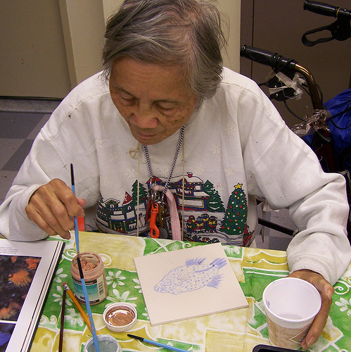 Fanny, Artist in Residence, creates a fish tile.
